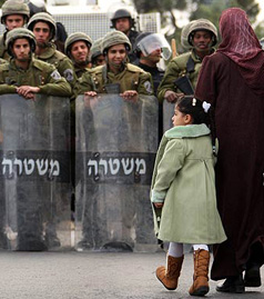 A Palestinian girl and her mother walk near anti-riot Israeli police in Arab East Jerusalem on January 16, 2009. The Israeli army locked down the occupied West Bank today as Hamas called for a day of "wrath" against the deadly offensive on Gaza. The West Bank will be closed off for 48 hours from midnight yesterday (2200 GMT), the army said in a statement. The announcement came after the Islamist movement Hamas called on Palestinians to observe a "day of wrath" on Friday by staging anti-Israeli protests after the weekly Muslim prayers. PATRICK BAZ/AFP/Getty Images)