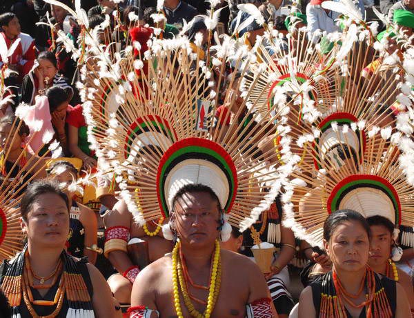 Tribal Angami Nagas with traditional attire looks on as they wait to perform during the first day of the annual celebration of Hornbill Festival at Kisama,Nagaland,India.  December 02  2008
